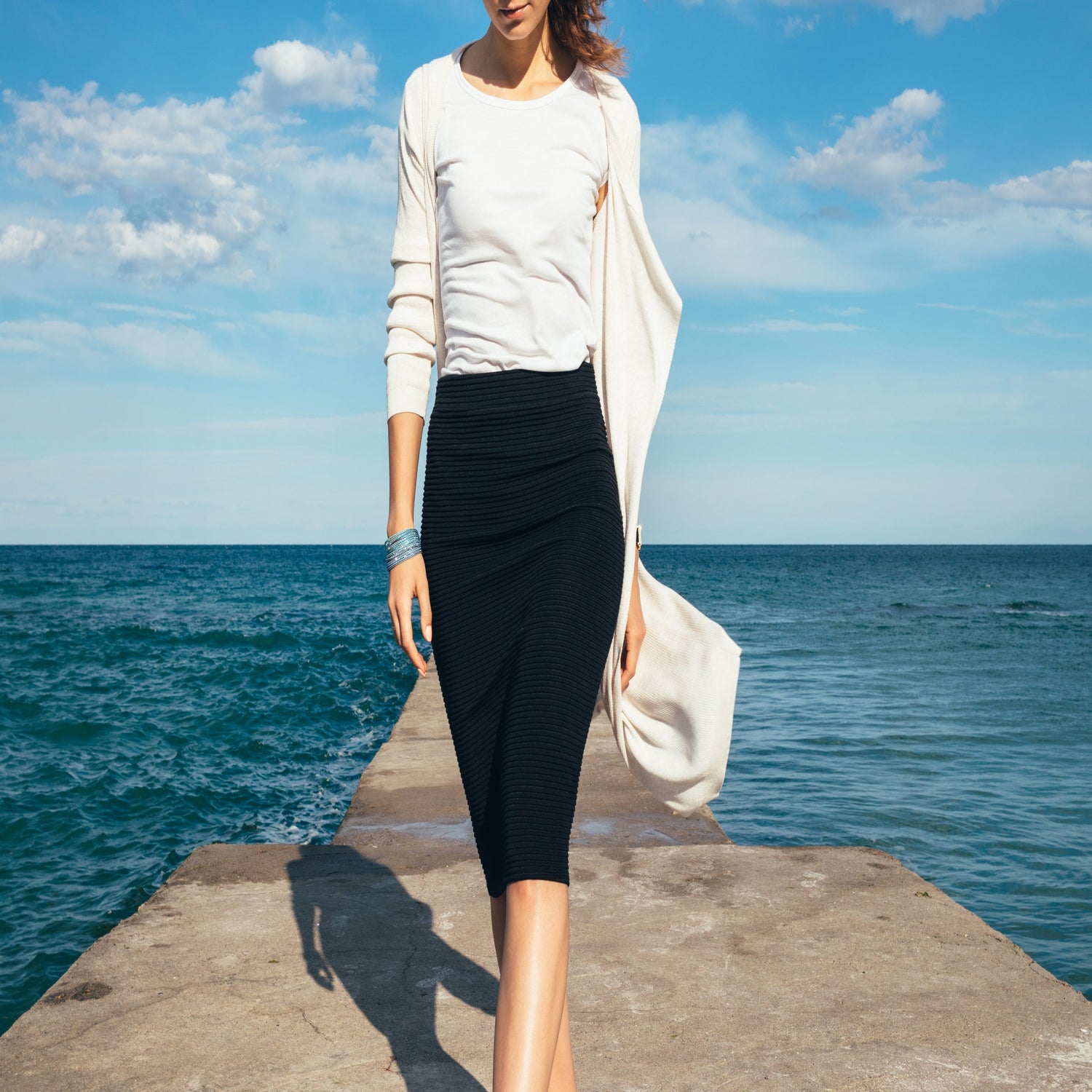 Woman walking on dock at the beach modelling skirt.
