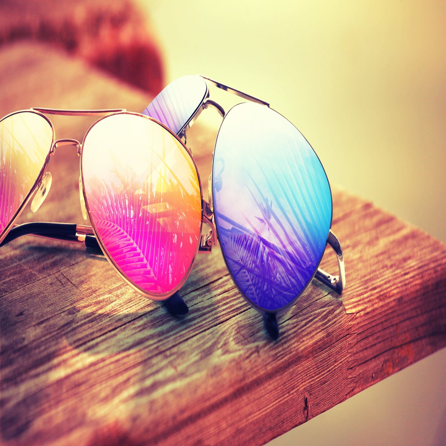 Pair of sunglasses on outdoor wooden table.