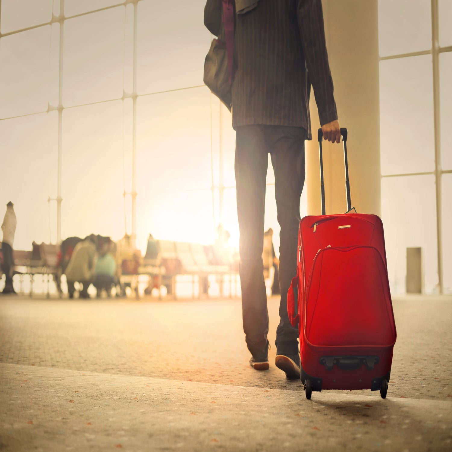 Man at airport with luggage trolley.
