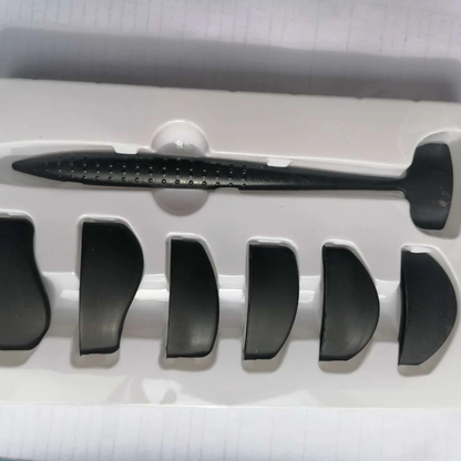 A black fin model kit against a white plastic holder, showing one large and several smaller fins. The setup suggests assembly or display.