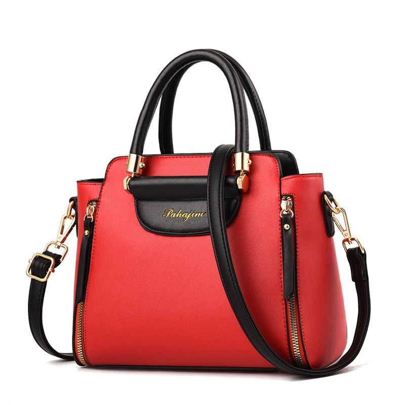 A stylish red handbag with black accents, featuring dual handles and a detachable shoulder strap, adorned with gold hardware.