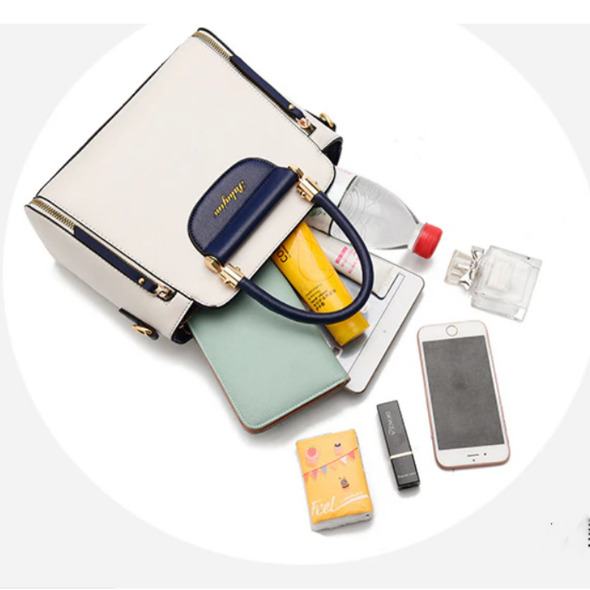 An open handbag with a water bottle, cosmetics, a notebook, a smartphone, a USB drive, and a perfume bottle scattered around.