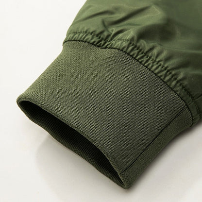 Close-up of a green jacket sleeve, featuring a ribbed cuff made of stretchy material. The fabric has a smooth texture, conveying a casual, cozy feel.