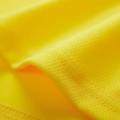 Close-up of vibrant yellow fabric, showcasing its smooth texture and fine stitching detail.