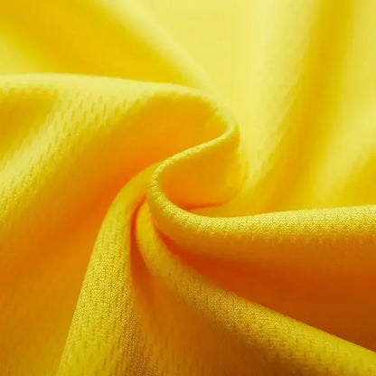 Close-up of vibrant yellow fabric, showcasing its soft, textured surface and gentle folds.