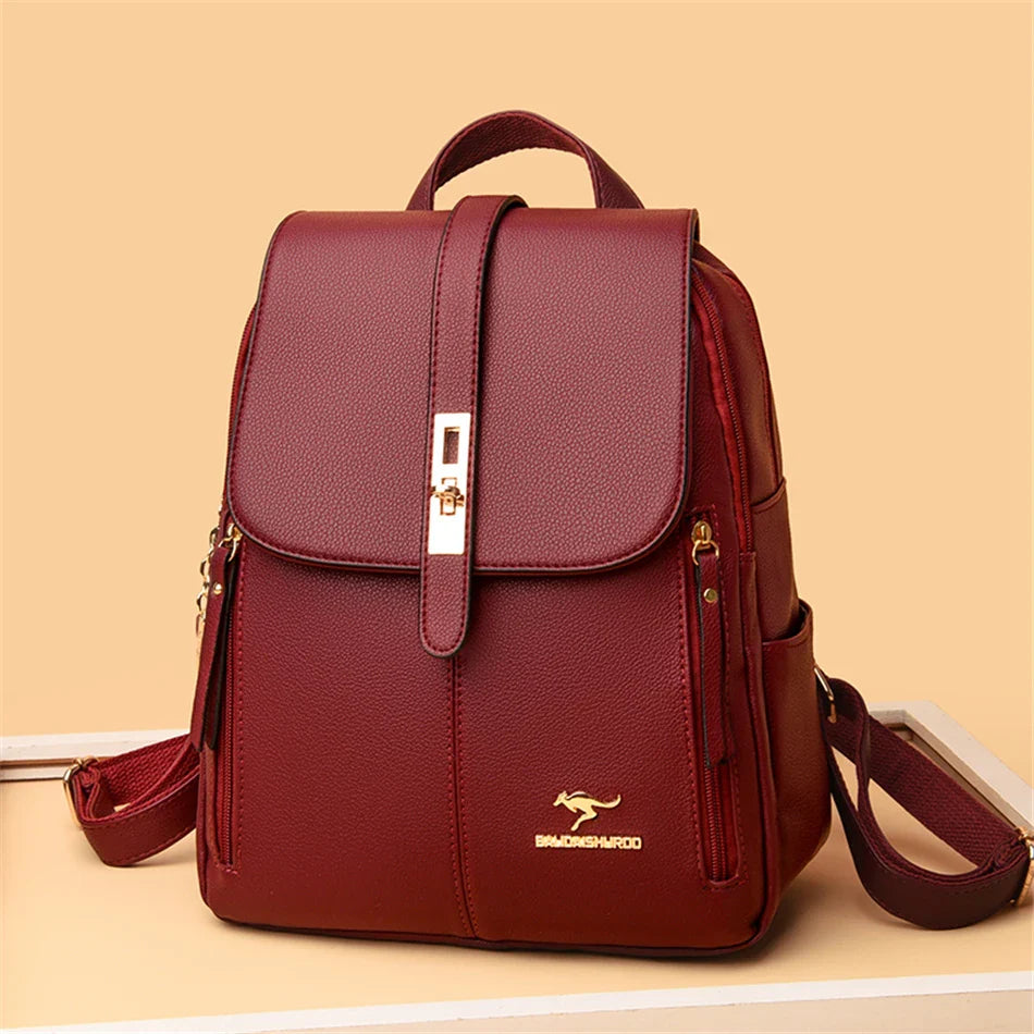 Elegant maroon backpack with a gold clasp, featuring side pockets and a sleek design, perfect for everyday use.