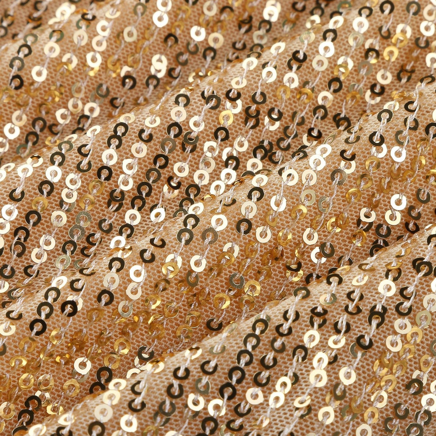Gold sequins densely cover a textured fabric, creating a shimmering effect. The surface undulates, reflecting light for a glamorous vibe.