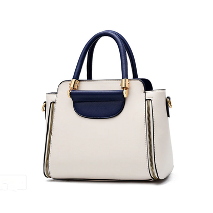 Stylish two-tone handbag with cream body and navy blue accents, featuring gold hardware and dual handles for easy carrying.