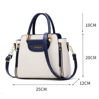 Stylish two-tone handbag in cream and navy, featuring gold accents and dimensions of 25x20x12 cm, with both handles and shoulder strap.