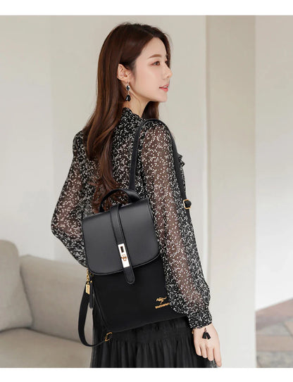 A woman wearing a black floral blouse and light skirt carries a sleek black backpack, showcasing elegant jewelry and hair.