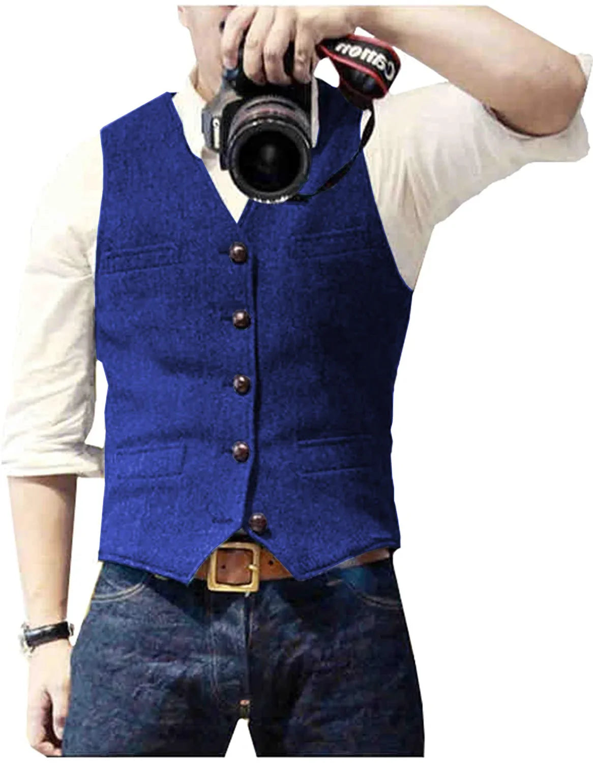A person wearing a blue vest and denim jeans poses for a photo while holding a camera, showcasing a casual yet stylish look.