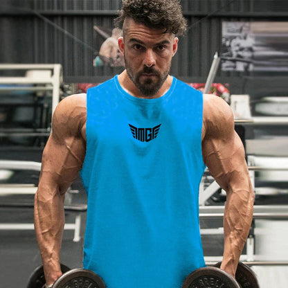 A muscular individual in a bright blue tank top stands in a gym, holding dumbbells, with weightlifting equipment in the background.