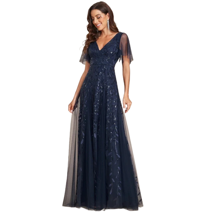 Woman wearing a navy blue evening gown with sheer sleeves and embroidered details. She smiles softly, exuding elegance and confidence against a plain background.