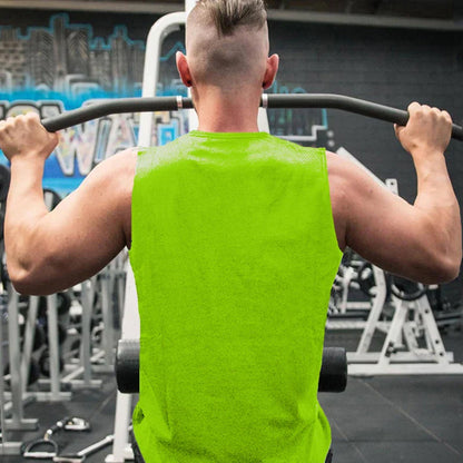 A muscular man in a neon green sleeveless shirt performs a pull-up in a gym, showcasing fitness equipment in the background.