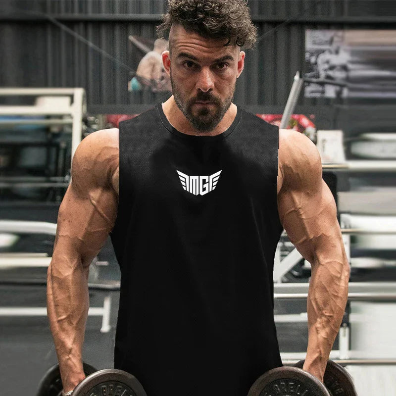 A muscular person in a sleeveless black shirt holds dumbbells in a gym, showcasing strength and dedication to fitness.