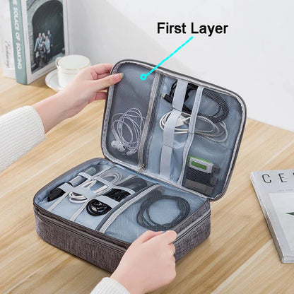 A person opens a storage bag for cables and devices, showcasing organized compartments for chargers and headphones.