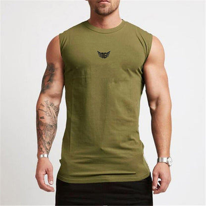 A muscular man in an olive green sleeveless shirt with a small black logo, showcasing his tattoos and wearing a watch.
