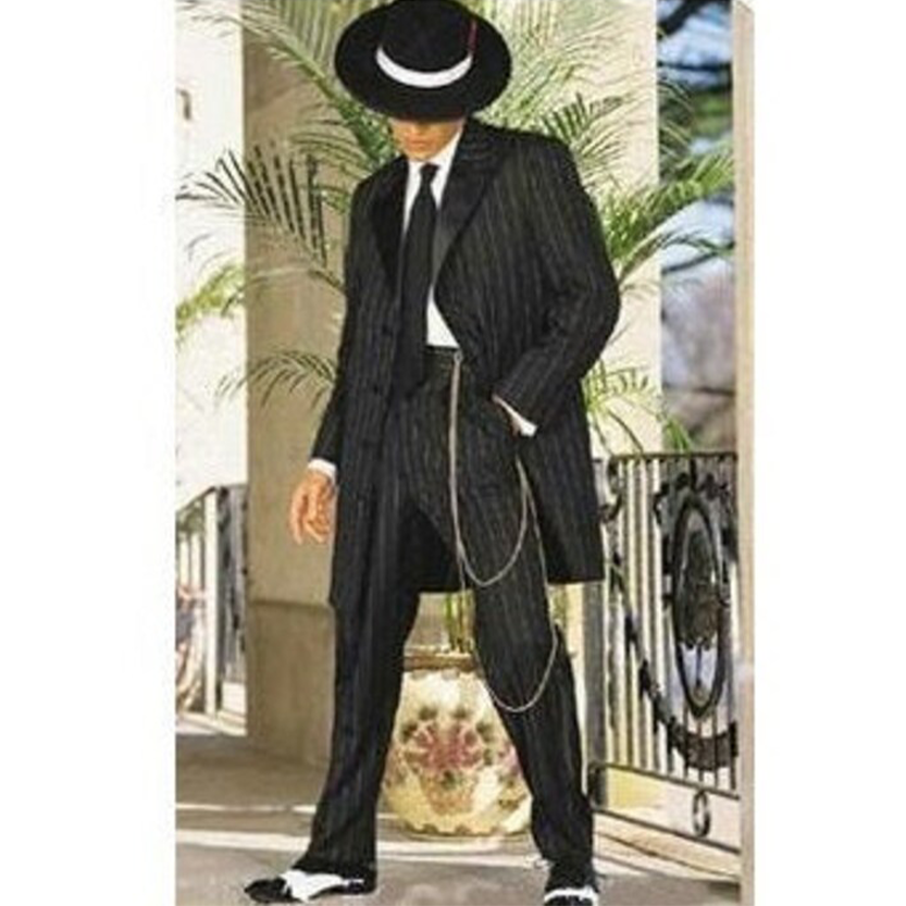 Man wearing a vintage black pinstripe zoot suit with a wide-brimmed hat and chain accessory. He stands elegantly next to a potted plant, exuding a retro vibe.