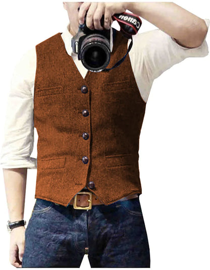 A man in a brown vest and white shirt holds a camera up, ready to take a photo, with denim jeans visible below.