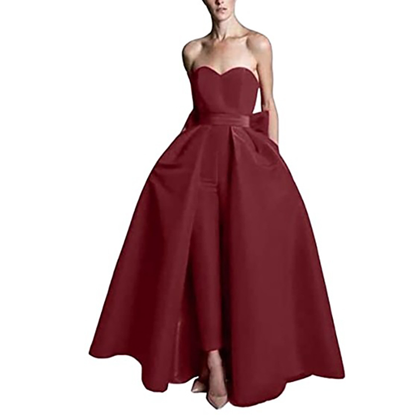 A woman in a strapless, deep red gown with a sweetheart neckline stands elegantly. The dress flares out at the waist, creating a voluminous silhouette.
