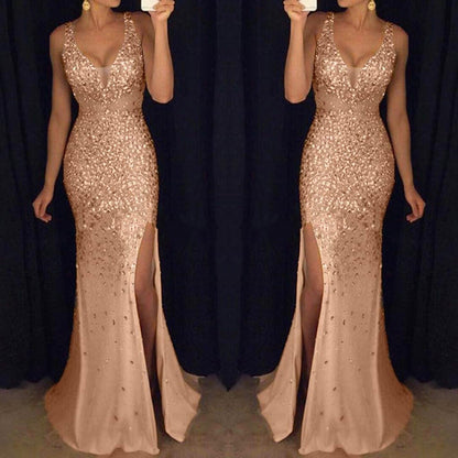 a woman in a shimmering, fitted, floor-length rose gold gown with a high slit, standing against a dark backdrop.