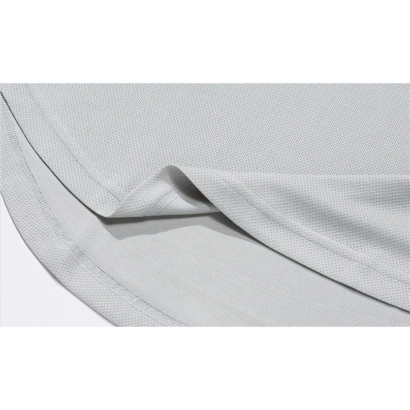 Close-up of a folded, light gray fabric with a textured surface, showcasing its soft drape and clean seam edges.