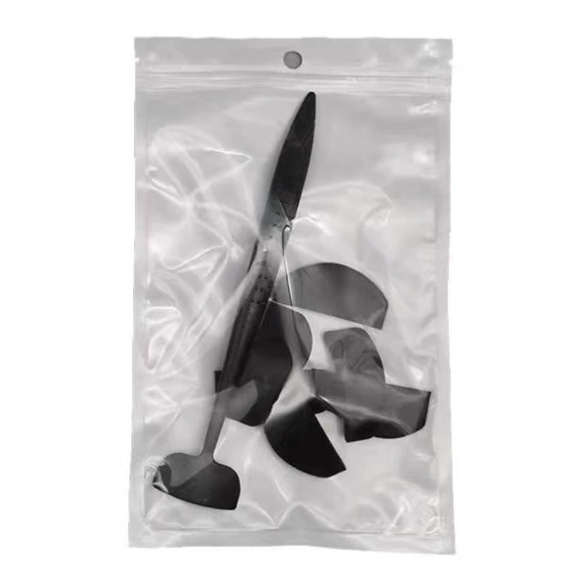 A clear plastic ziplock bag contains a black tool with a blade and multiple rounded black pieces, possibly replacement parts, creating a utilitarian and organized tone.