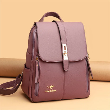 Stylish purple backpack with a flap closure and gold accents, featuring side pockets and a logo, set against a warm background.