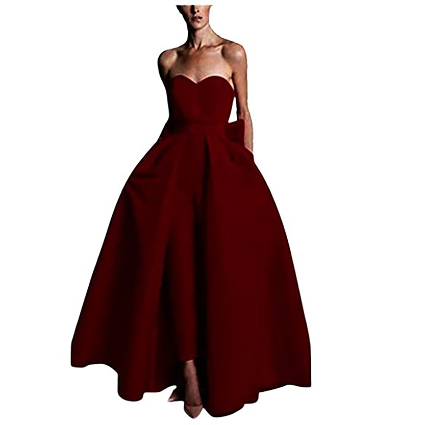 A woman wearing an elegant, strapless dark red gown with a fitted bodice and full skirt, conveying sophistication and grace against a white background.