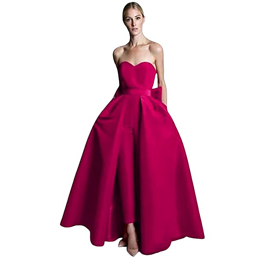 A woman in a strapless, vibrant pink gown with a heart-shaped bodice and full skirt stands confidently, exuding elegance and sophistication.