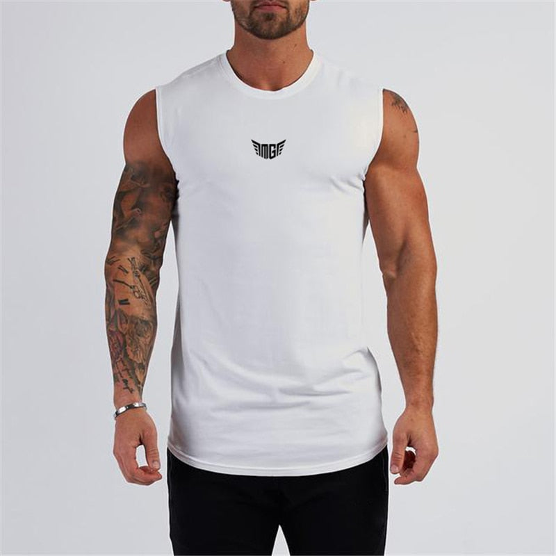 A muscular man with tattoos wears a white sleeveless shirt featuring a black logo on the chest, posing against a plain background.